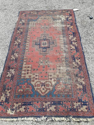 Lot 1080 - Eastern rug with geometric decoration on red and blue ground, 228cm x 125cm