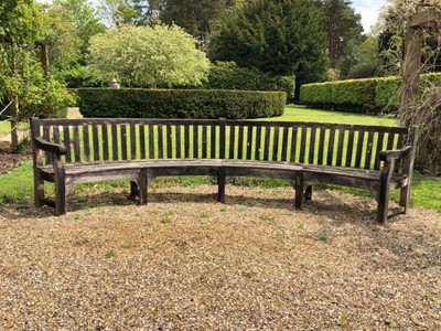 Lot 1402 - Large teak garden bench of semi-circular form, approximately 350cm wide