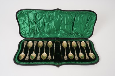 Lot 314 - Set of twelve late Victorian silver gilt teaspoons and matching tongs, in original fitted case