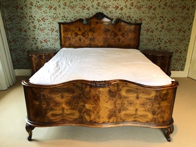 Lot 1428 - Early 20th century walnut bedstead, the carved and shaped headboard with reeded pillars, serpentine footboard, side rails and base, 204cm long x 178cm wide, together with a matching pair of bedside...