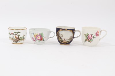Lot 121 - Four 18th century continental porcelain cups, various marks including crossed swords and interlaced L's, one cup finely painted with a landscape and seascape on a cobalt ground, another with birds...