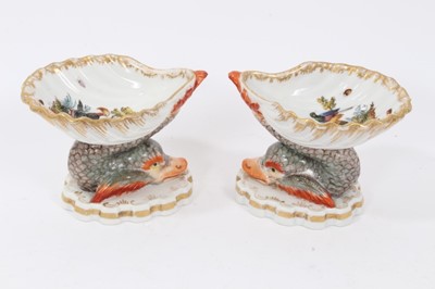 Lot 136 - Pair of Berlin porcelain salts, of shell form, painted with exotic birds and insects, supported by mythical dolphins on shaped bases, underglaze blue marks to bases, 6.5cm high
