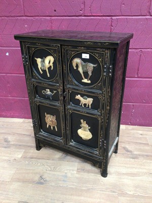 Lot 355 - Oriental lacquered two door cupboard decorated with applied Oriental plaques, 61cm wide, 29.5cm deep, 86.5cm high