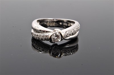 Lot 123 - 14ct white gold diamond cross over ring