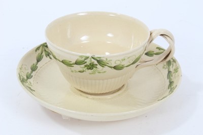 Lot 209 - Leeds creamware tea cup and saucer, c.1780, semi-fluted form, the cup with double strap handle, painted in green enamel with foliate swags, the saucer measuring 12cm diameter