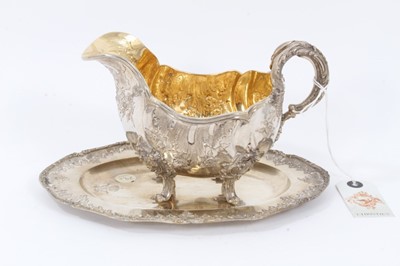 Lot 35 - Late 19th Century German Silver Sauce Boat from the Royal Prussian Collection, of oval form with reeded border, repousse and chased with rocaille, flowers and foliage, with bifurcated foliage-cappe...