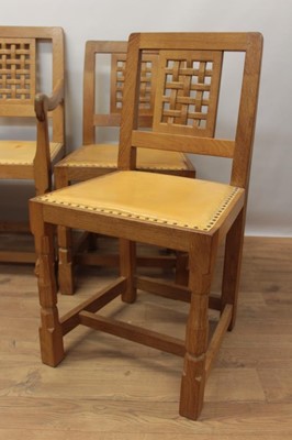 Lot 1297 - Set of five Robert Mouseman Thompson carved oak dining chairs, each with lattice carved back and close stud leather upholstery on chamfered supports with signature mouse to front leg, to include on...