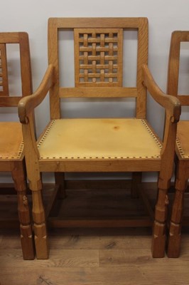 Lot 1297 - Set of five Robert Mouseman Thompson carved oak dining chairs, each with lattice carved back and close stud leather upholstery on chamfered supports with signature mouse to front leg, to include on...