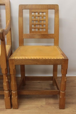 Lot 1297 - Set of five Robert Mouseman Thompson carved oak dining chairs, each with lattice carved back and close stud leather upholstery on chamfered supports with signature mouse to front leg, to include on...