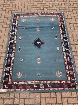 Lot 187 - Old rug decorated with figures and animals on blue ground  228cm x 160cm