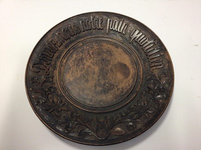 Lot 2200 - French treen bread board, carved in relief with a motto and foliate patterns, 28cm diameter
