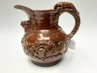 Lot 90 - Castle Hedingham Edward Bingham brown glazed pottery jug, with lion on handle and mask decoration, 22cm high