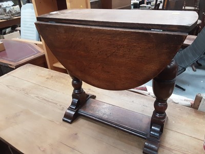 Lot 873 - Oak drop leaf table on turned end standards and a nest of three oak occasional tables