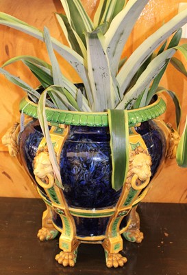 Lot 187 - Large 19th century English majolica jardinière, decorated in relief with lion masks and paw feet on six columns, on a marbled blue ground, 44.5cm height, containing a plant