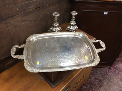 Lot 43 - Silver plated two handled tray it's engraved foliate decoration and gadrooned borders, together with a pair of decorative plated candlesticks