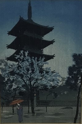 Lot 18 - Japanese woodblock print in frame, depicting a female figure holding a parasol with a pagoda in the background, possibly after Shiro Kasamatsu