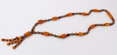 Lot 38 - Amber bead necklace with white metal spacers and tassel terminal