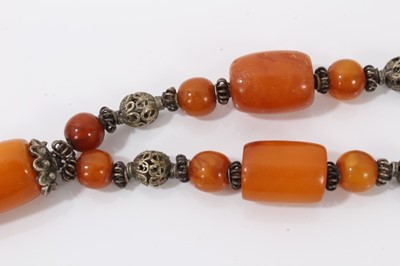 Lot 38 - Amber bead necklace with white metal spacers and tassel terminal
