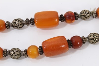 Lot 38 - Amber bead necklace with white metal spacers and tassel terminal