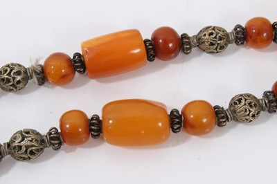 Lot 38 - Amber bead necklace with white metal spacers and tassel terminal