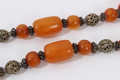 Lot 38 - Amber bead necklace with white metal spacers and tassel terminal