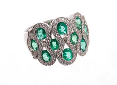 Lot 1969 - Emerald and diamond dress ring with ten oval mixed cut emeralds within brilliant cut diamonds, all in 18ct white gold setting. Finger size approximately O.