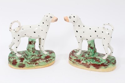 Lot 68 - Pair of Staffordshire pottery models of Dalmatians, shown standing on naturalistic bases, 16cm high