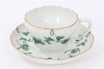 Lot 74 - Bristol cup and saucer, circa 1772-75, decorated in green enamels with swags of flowers, with gilt rims, B marks to bases, the saucer measuring 12cm diameter
