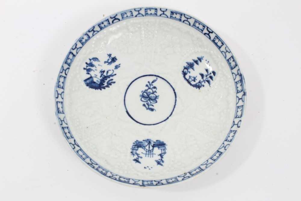 Lot 80 - Lowestoft blue and white saucer, circa 1765, relief moulded, with circular panels containing Chinese landscapes and a patterned border, 12.25cm diameter