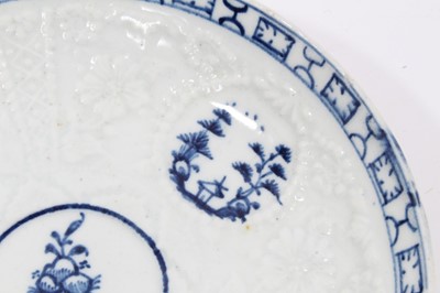 Lot 80 - Lowestoft blue and white saucer, circa 1765, relief moulded, with circular panels containing Chinese landscapes and a patterned border, 12.25cm diameter