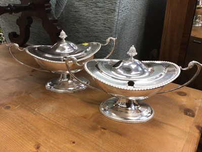Lot 49 - A pair of silver plate sauce tureens in the Adam style of oval form on a raised foor with gadroon border, swan handles and pineapple finial