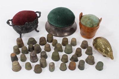 Lot 795 - Antique brass hedgehog pin cushion, three further pin cushions and a collection of antique thimbles