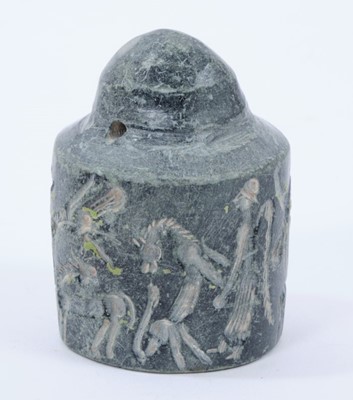 Lot 929 - Rare early carved stone cylinder seal, possibly Assyrian, with pierced terminal and profusely carved with figures ans animals, similarly carved to the foot, 6cm high