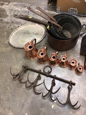 Lot 252 - Graduated set of 19th century copper pans, also iron hanging rack copper measures