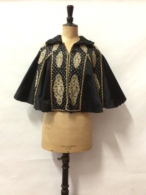 Lot 2053 - Victorian black silk satin cropped Mourning cape with chain stitch embroidery, sequins and lace.  Egdes trimmed with ruffled ribbon.