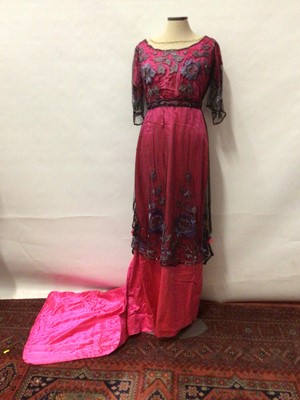 Lot 2062 - Circa 1910 Evening dress in cerise pink satin overlaid by black beaded and embroidered net.  Dress has high waistline and narrow skirt with train, train has weighted hem.