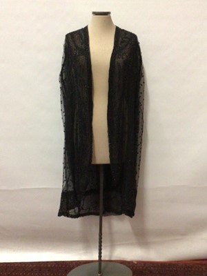 Lot 2070 - 1920's Longline black net evening cape with floral beading. Loose fitting with silk chiffon lining. Handstitched construction.