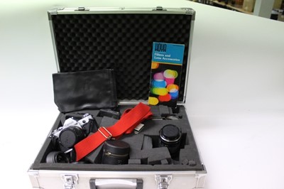 Lot 2699 - Two boxes and a silver carry case containing vintage cameras, lenses and accessories (listing enclosed)