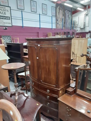 Lot 1047 - 19th century mahogany bowfront wardrobe with two doors above enclosing hanging rail, two short and three long graduated drawers below on splayed bracket feet, 120.5cm wide, 58cm deep, 207cm high