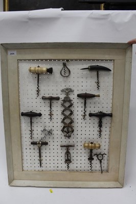 Lot 2429 - Collection of antique corkscrews, mounted on a board