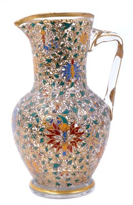 Lot 221 - Fine enamelled glass jug, mid to late 19th century, decorated with Persian-style scrolling foliate patterns in red, blue, green, yellow and white enamels, with gilding in relief, 25.5cm high