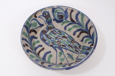 Lot 120 - Persian/Middle Eastern tin-glazed pottery bowl, painted with a bird and a foliate pattern in blue, green and black, 24.5cm diameter