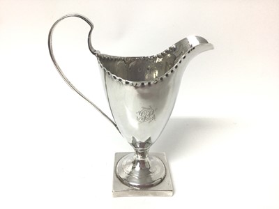 Lot 60 - Georgian silver cream jug of helmet shaped form, on square foot