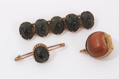 Lot 198 - Egyptian Revival brooch mounted with five scarab beetles, together with another mounted with a single scarab beetle and a locket made from a hazelnut (3)