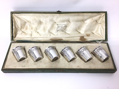 Lot 133 - Cased set of six French silver spirit cups, with swag patterns in relief and everted rims, 4cm high