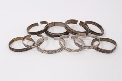 Lot 345 - Ten Chinese white metal bangles with floral scroll decoration