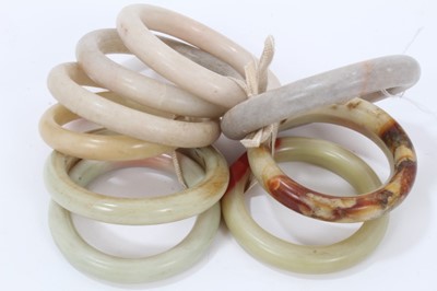 Lot 346 - Ten jade/ green hard stone polished bangles