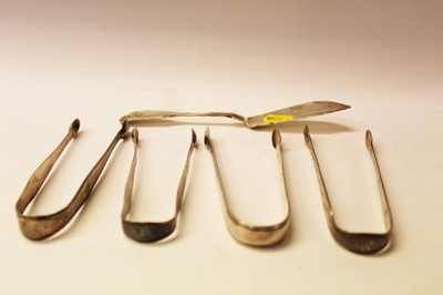Lot 2579 - Four pairs of Georgian silver sugar tongs and a butter knife (5)